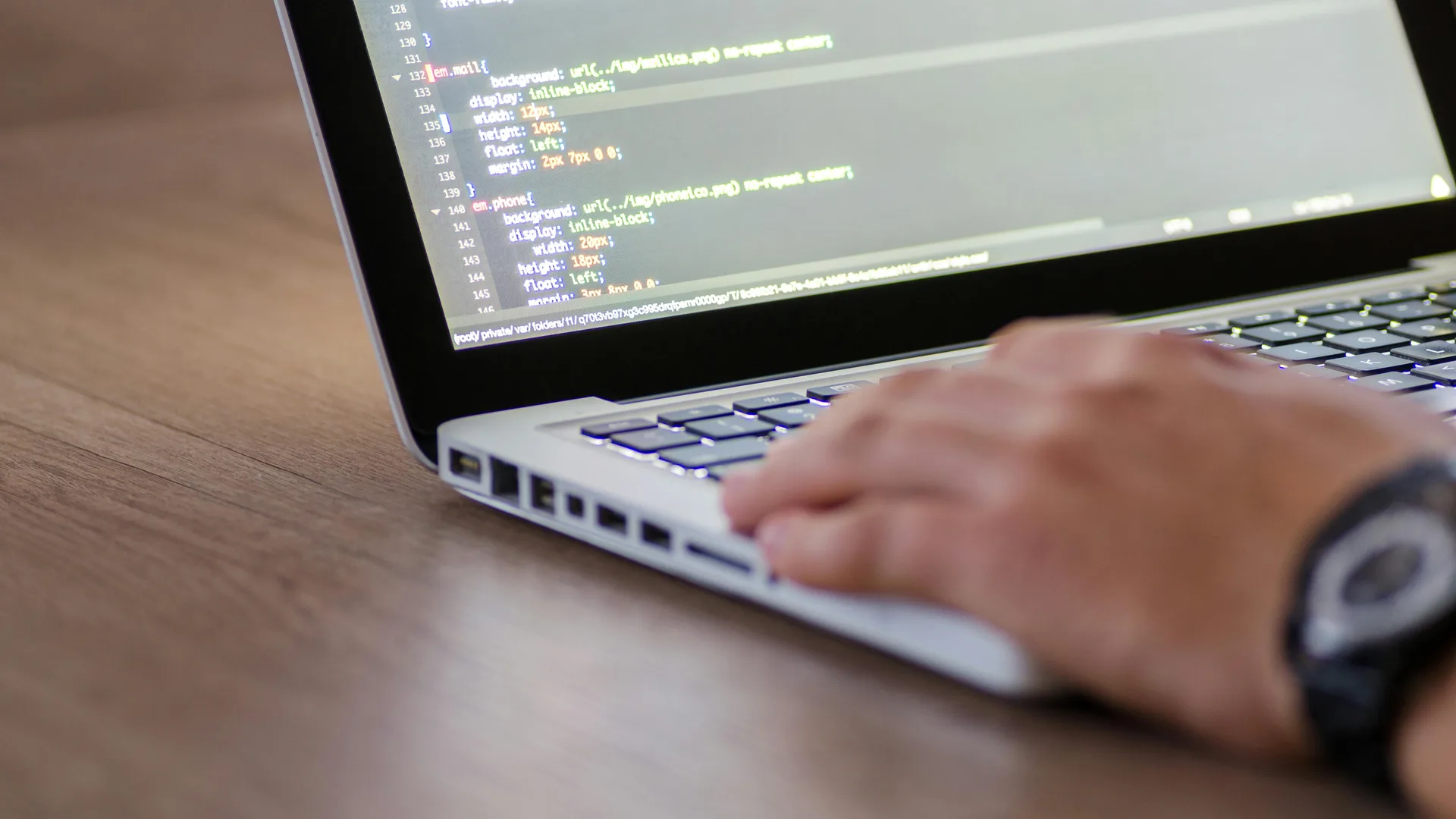 Laptop showing website development code for a business site